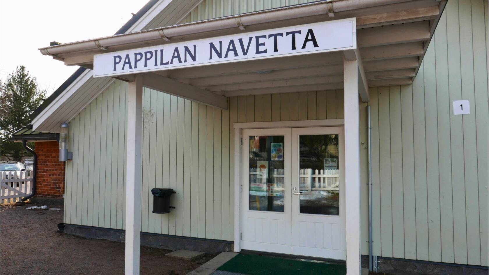 Pappilan navetan sisäänkäynti, jonka ovikatoksen yllä lukee kyltissä Pappilan navetta.