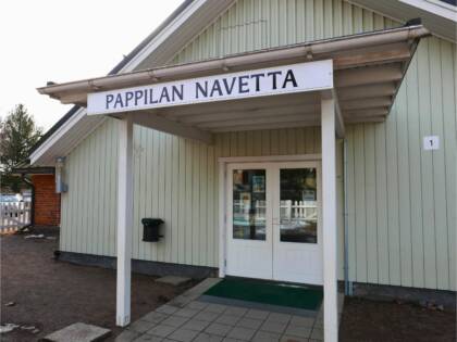Pappilan navetan sisäänkäynti, jonka ovikatoksen yllä lukee kyltissä Pappilan navetta.