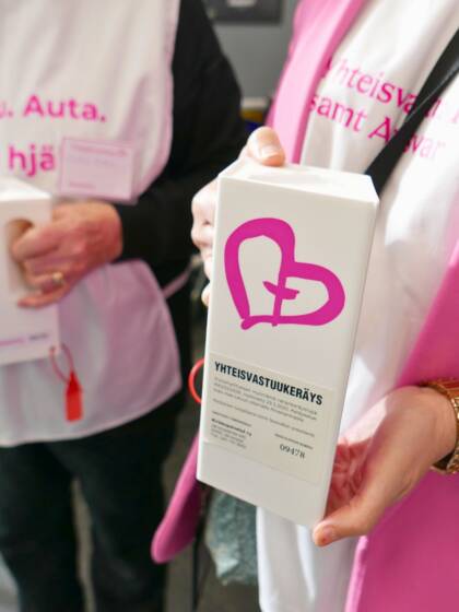 Kaksi henkilöä pitävät kädessään Yhteisvastuu-keräyslippaita.