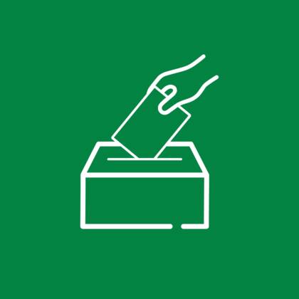 Grafiikkakuva, jossa vihreällä pohjalla käsi pudottamassa lipuketta vaaliuurnaan piirrettynä valkoisella.