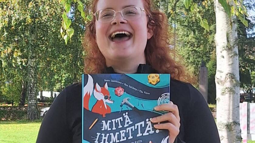 Saara esittelee uutta kirjaa ja sen kantta.