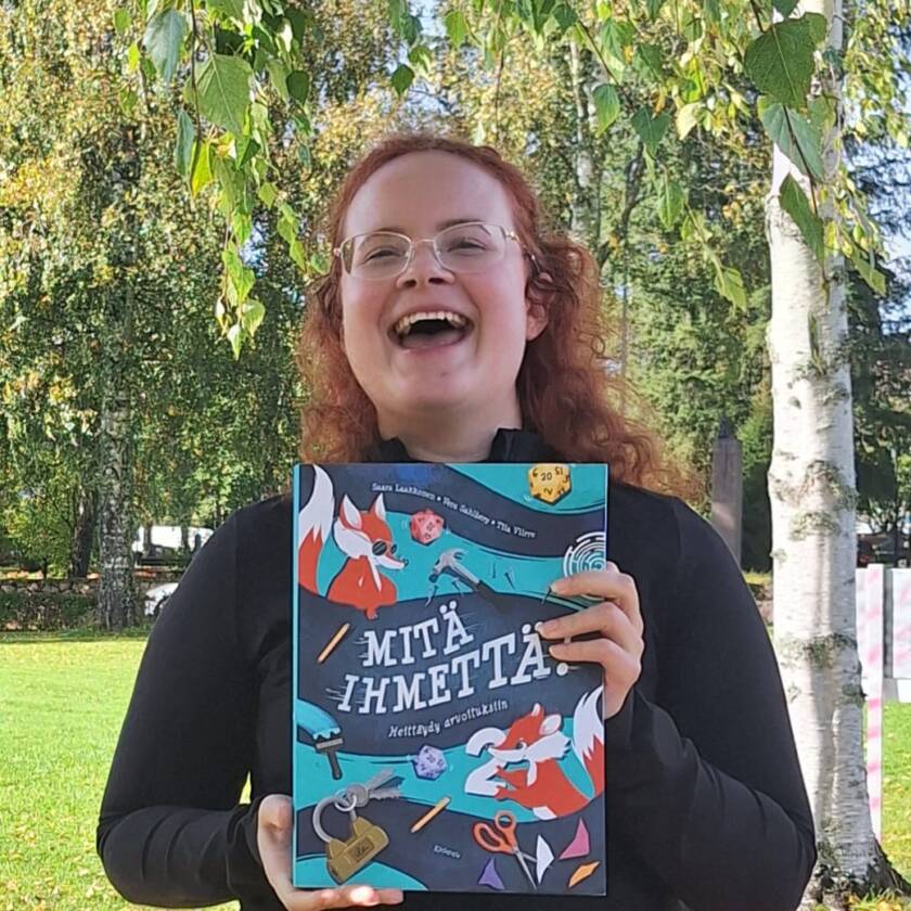 Saara esittelee uutta kirjaa ja sen kantta.